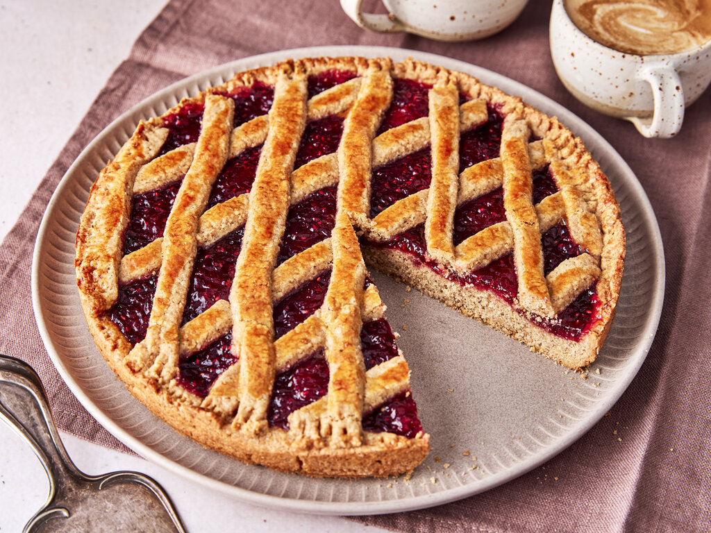 Kuchenteller mit einer so genannten Linzertorte. Ein Stück ist bereits herausgeschnitten